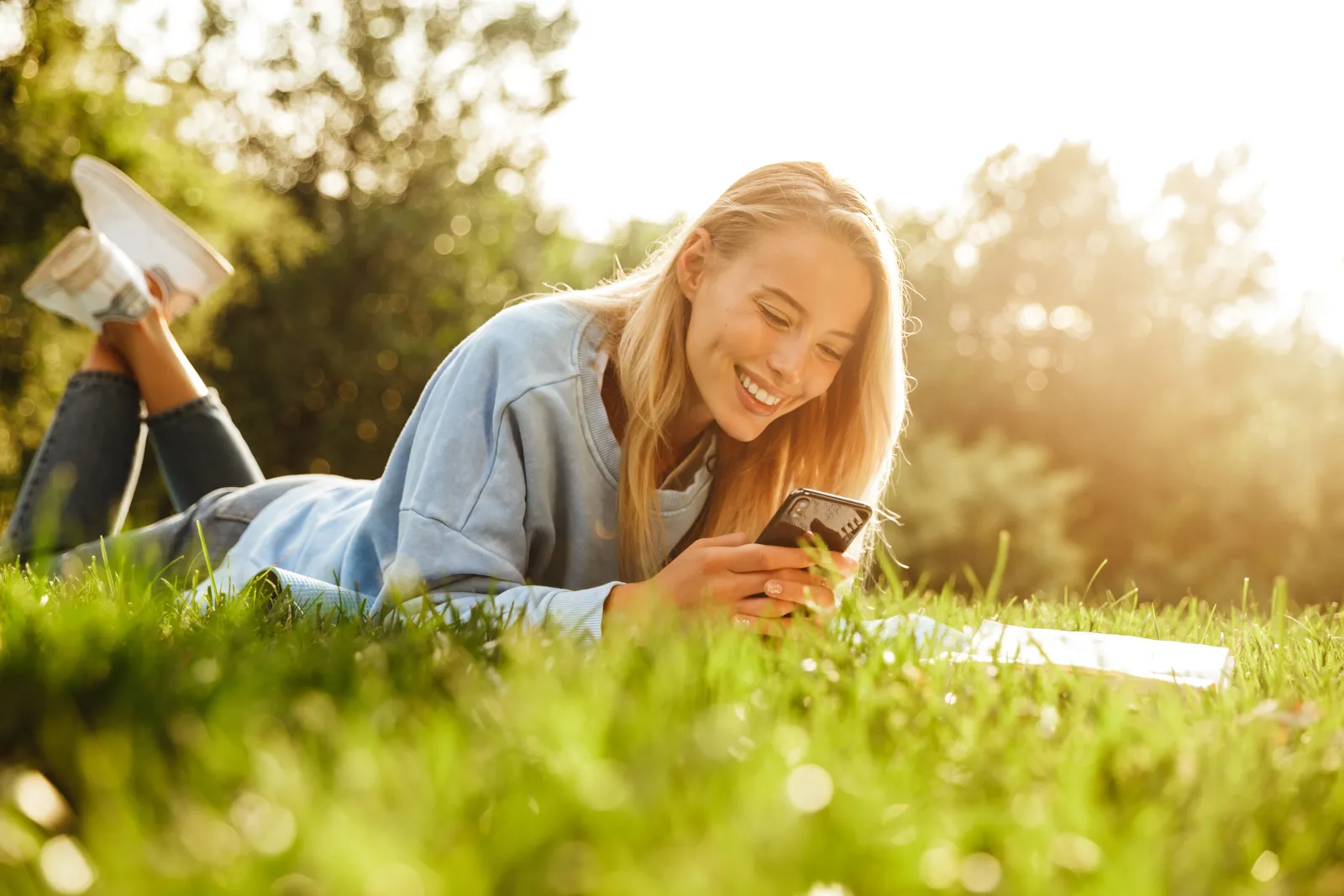 woman using phone in grass